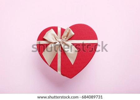 Heart gift box with ribbon on pink background