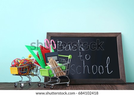 Shopping carts with stationery and inscription Back To School