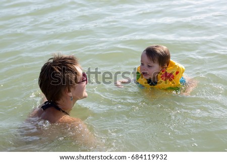 Mother with her son swimming in a lake