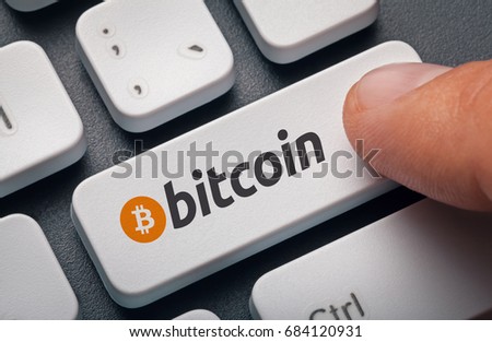 Index finger pressing computer key with bitcoin logo. Fear or Missing Out (Fomo), crypto trading or banking concept.