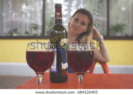 the wine glasses on the table in the background of girls