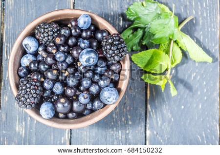 Forest berries in a clay plate. Low depth of field. Berry decoration.