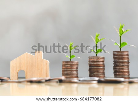 wooden house model and step of coins stacks with tree growing on top, loft style background, money, saving and investment or family planning concept.