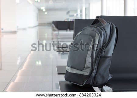 Abandoned, unattended cabin backpack on chair at the gates area of an airport. Royalty-Free Stock Photo #684205324