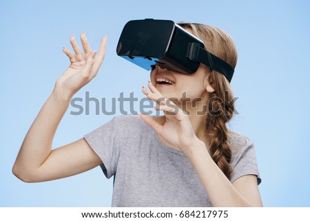 Beautiful young woman on a blue background with glasses virtual reality.