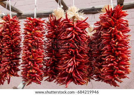 Bunches of red chili pepper drying outside