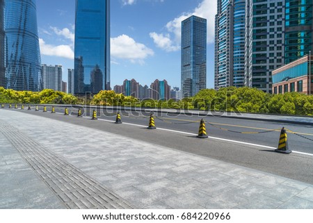 cityscape and skyline of shanghai from empty asphalt road
