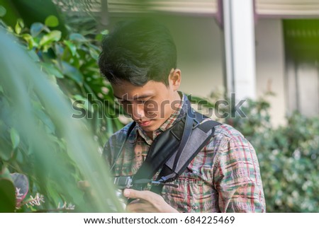 Young asian man  touching with camera before photographing.