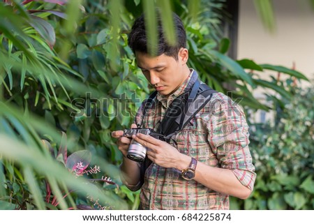Young asian man  touching with camera before photographing.