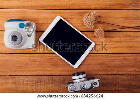 Creative flat lay photo of workspace desk with instant camera and retro camera