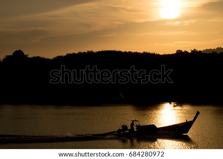 The boat is sailing in the river. The sunset is about to fall.(Silhouette)