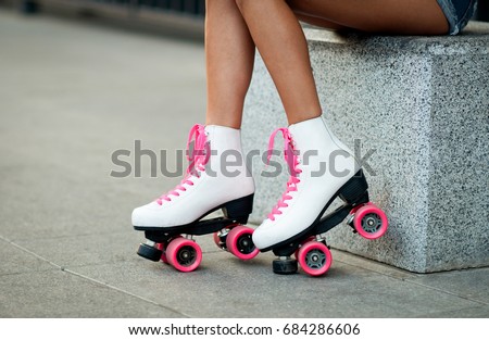 Woman's legs in a vintage roller skates.  white quad roller skates. Outdoor. 