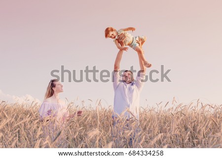 happy family in cereal field at sunset