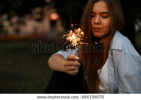 Close-up picture of bright Bengal fire in women's hands, The concept of the holiday