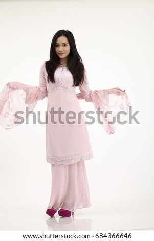 malay woman wearing pink baju kurung on the white background