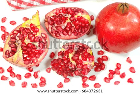 Closeup view of Pomegranate fruit and seeds on a white background.