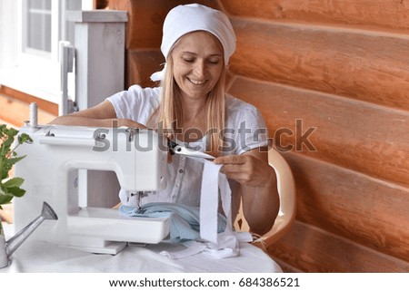 A woman sews on a sewing machine 