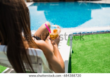 Woman relaxing on chaise lounge with cocktail.Time summer photo.