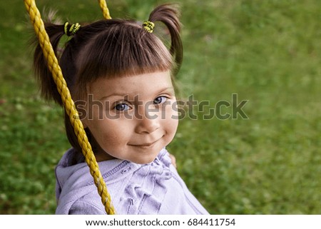 Young child on swing in the Park outdoors/smiling little girl riding on a swing