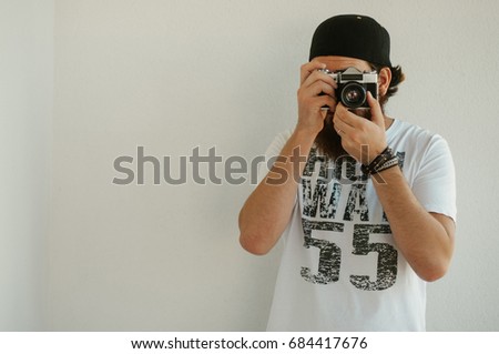 Hipster man taking a picture with vintage camera. 