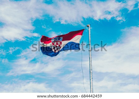 Flag of Croatia waving in the wind with highly detailed fabric light blue sky on the background and space for editing