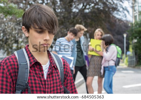 Unhappy Boy Being Gossiped About By School Friends Royalty-Free Stock Photo #684505363