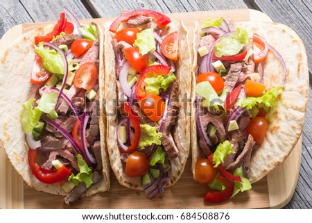 Mexican pork tacos with vegetables on wooden rustic background . Top view