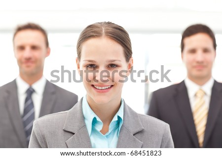 Cheerful businesswoman standing in front of two businessmen at work