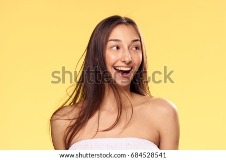 Happy woman looking away on a yellow background                               