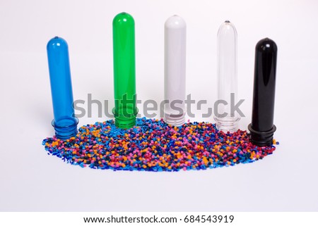 Clear PET Preforms on white background for presentation. Preforms and raw materials of different colors.