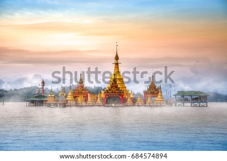 A breathtaking view to the Floating Pagoda Shwe Myitzu in fog at sunrise. Indawgyi Lake Wildlife Sanctuary, one of the largest inland lakes in Southeast Asia. Kachin State, Myanmar Royalty-Free Stock Photo #684574894