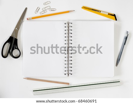 Open notebook with various stationeries or office supplies, white blank pages