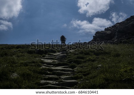 tourist walks to the top of a rocky mountain