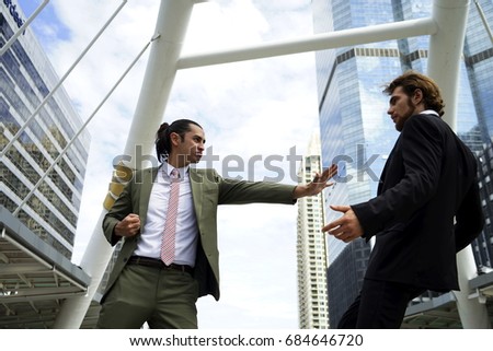 two Businessmen fight or crash or battle together outdoors