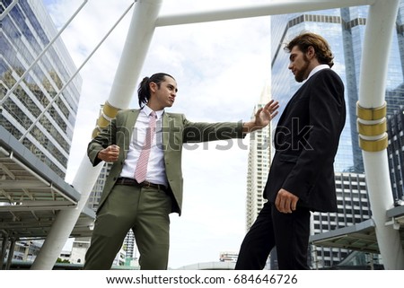 two Businessmen fight or crash or battle together outdoors