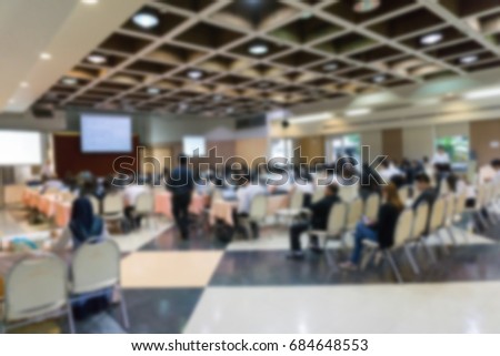 BLURRED image of seminar room with full of people listening to speaker presentation.  or business coaching manager teaching about business network analysis. business coaching, study concept.