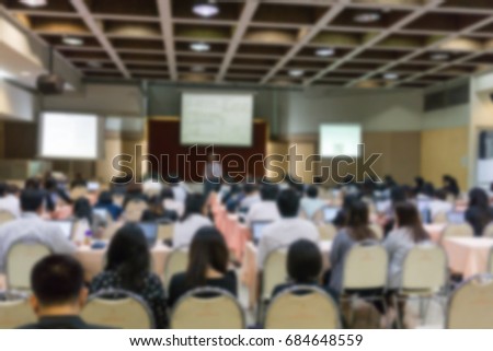 BLURRED image of seminar room with full of people listening to speaker presentation.  or business coaching manager teaching about business network analysis. business coaching, study concept.