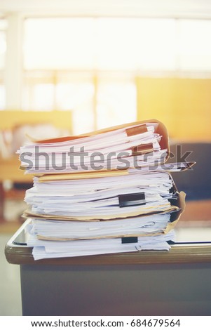 Paper business documents of unfinished stacked on office desk archive,in archive analyzing the market and considers on the size of future profits on table office.