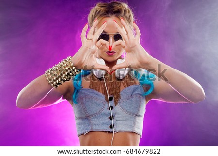 Young fashionable girl in disco style. Disco girl shows hands sign heart. Retro style
