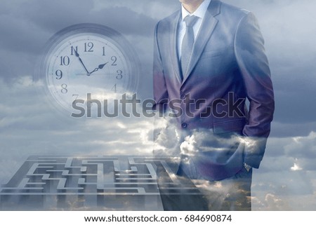 Businessman thinking in front of the maze against the sky.