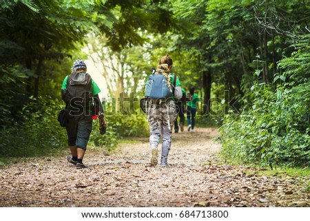 Traveler with backpack and trusty camera with the device enjoying in area forest