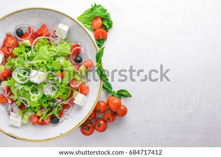 Greek salad of fresh vegetables and cheese. On a wooden background. Top view. Free space for your text.