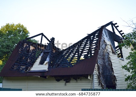 Damage to the roof from the fire. The house, completed by Siding, suffered from a fire. Fire safety Royalty-Free Stock Photo #684735877