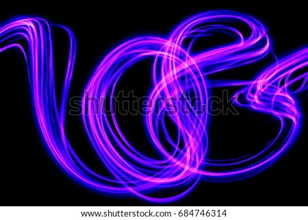 Long exposure, light painting photography, purple and pink swirl against a black background