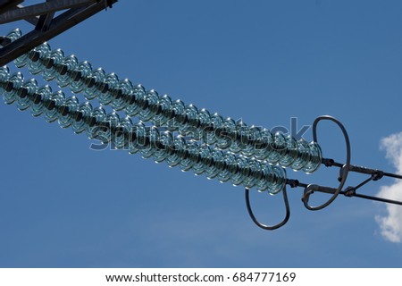 Garland of high-voltage glass insulators. Royalty-Free Stock Photo #684777169