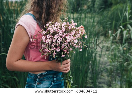 Beautiful woman with bouquet of pink flowers and copy space