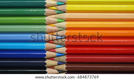 Colorful row of colored pencils sharp facing each other, Pattern background