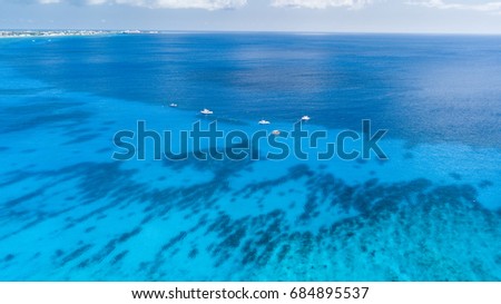 Aerial view of dive boats over a coral reef and large shipwreck in tropical waters