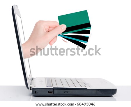 hand with credit card comes from laptop screen