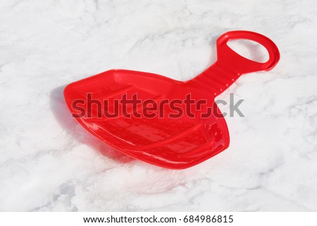 Modern plastic red sledding on the snow
